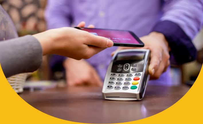 Customer paying contactless with a phone at a card terminal